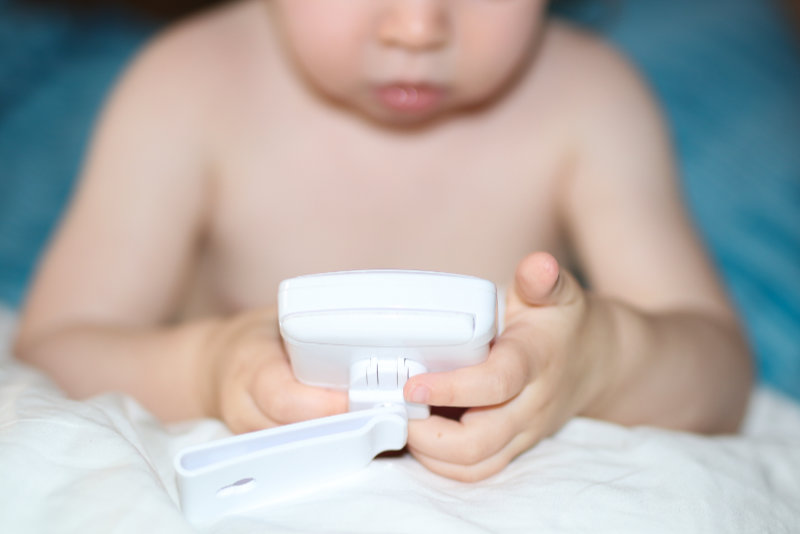 Kleinkind mit Babyphone in den Händen